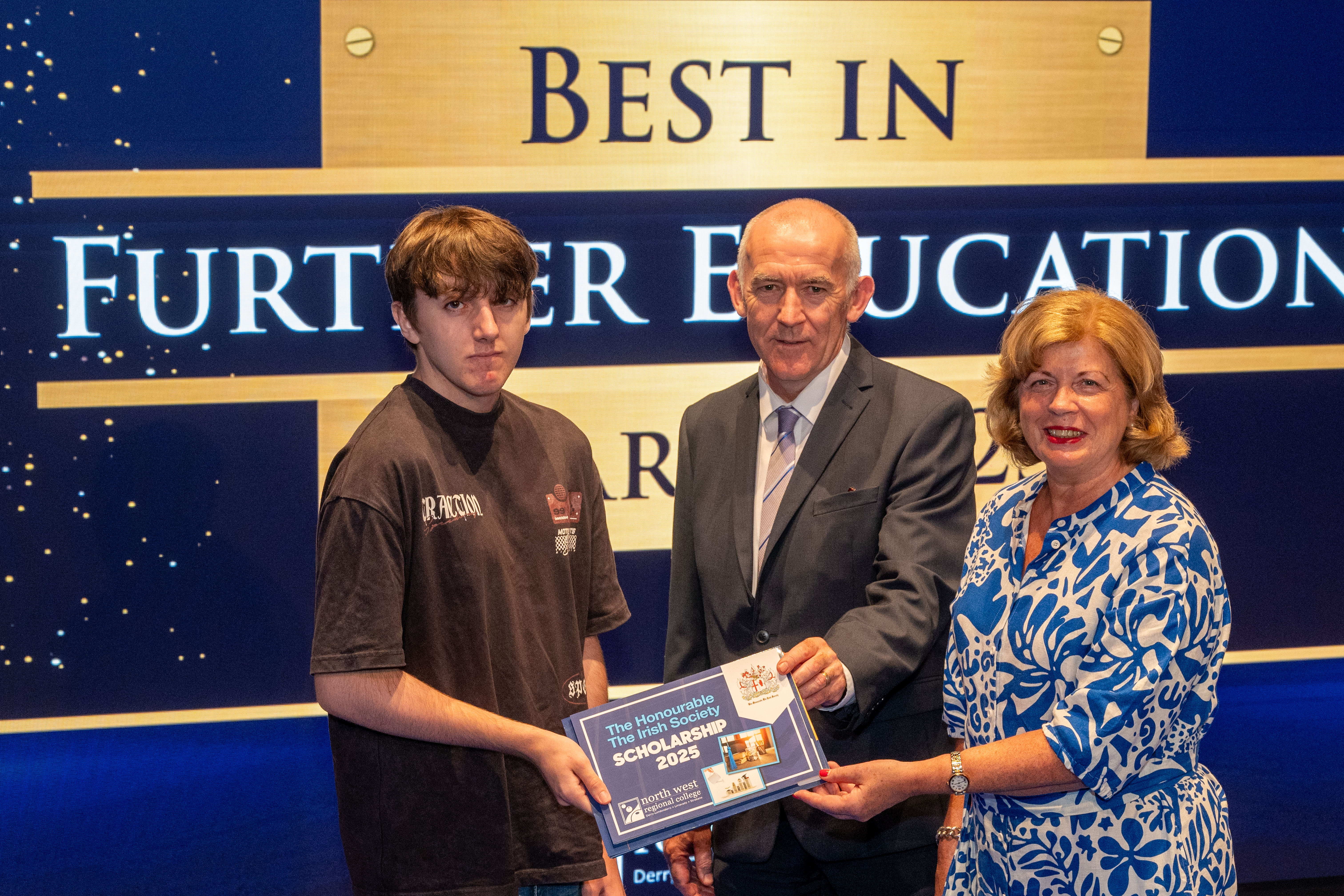 Two men and a woman hold up an awards for the Honourable the irish scholarships.
