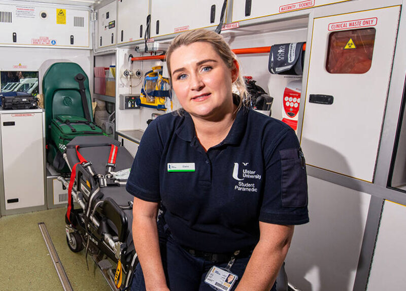 Female student paramedic sitting in the back of an ambulance