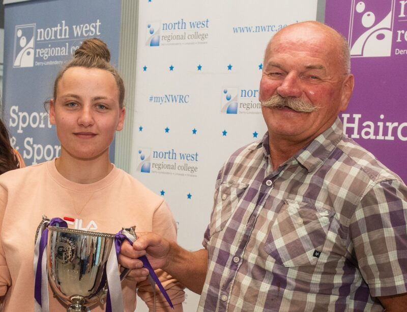 A man and woman holding a trophy